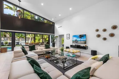 a living room with white furniture and large windows at Coconut Grove Villa with heated Pool sleeps 12 in Miami
