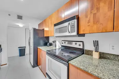 a kitchen with a stove and a microwave at Luxurious private unit with parking in Miami
