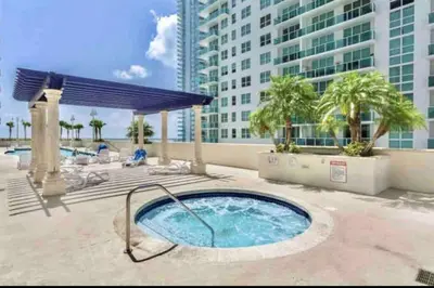a hot tub on a patio with a building at Luxurious private unit with parking in Miami