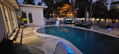 a swimming pool in a backyard at night at Beachside Bliss Pool Retreat Half mile to Beach in Hollywood