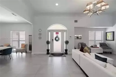 a white living room with a white couch and a ceiling at Beachside Bliss Pool Retreat Half mile to Beach in Hollywood