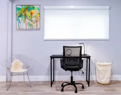 a desk with a clock and a chair in a room at Casa Tropicana - Heated Pool, Game Room & Mins from beach in Hallandale Beach