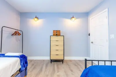 a bedroom with blue walls and a bed and a dresser at Casa Tropicana - Heated Pool, Game Room & Mins from beach in Hallandale Beach