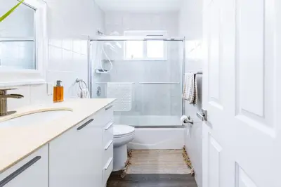 a white bathroom with a toilet and a sink at Casa Tropicana - Heated Pool, Game Room & Mins from beach in Hallandale Beach
