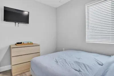 a bedroom with a bed and a dresser with a flat screen tv at Sistrunk Shades Villa #4 - Townhome Downtown Fort Lauderdale Near Cruise Port & FLL in Fort Lauderdale
