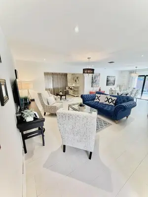 a living room with a blue couch and chairs at Stay Central: Relax in Our Heated Pool Oasis in Miami
