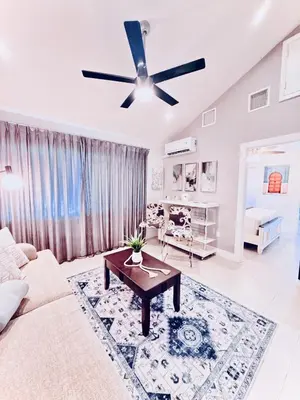 a living room with a couch and a ceiling fan at Stay Central: Relax in Our Heated Pool Oasis in Miami