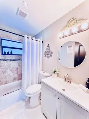 a bathroom with a sink toilet and a mirror at Stay Central: Relax in Our Heated Pool Oasis in Miami