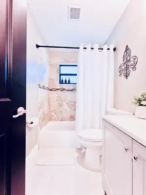 a white bathroom with a toilet and a shower at Stay Central: Relax in Our Heated Pool Oasis in Miami