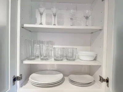 a cupboard filled with glasses and plates and bowls at Stylish Stay Close to UM City Vibes in Miami