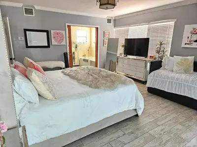 a bedroom with two beds and a flat screen tv at Pool Paradise Half mile to Beach w Massive Yard! in Hollywood