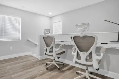 two chairs and a desk in a room with white walls at Sistrunk Shades Entire Compound 5 Homes 50 Guests in Fort Lauderdale