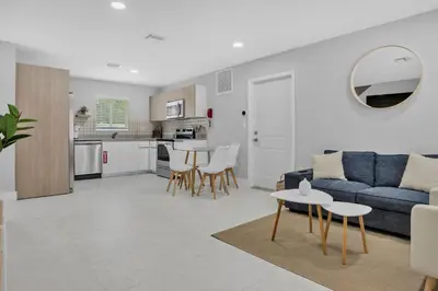 a living room with a blue couch and a table at Sistrunk Shades Entire Compound 5 Homes 50 Guests in Fort Lauderdale