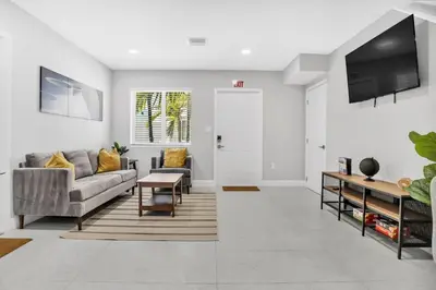 a living room with a couch and a tv at Sistrunk Shades Entire Compound 5 Homes 50 Guests in Fort Lauderdale
