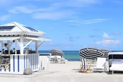 a group of chairs and umbrellas on the beach at Insta Worthy Modern Bungalow in Homestead