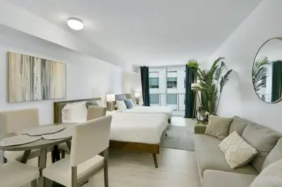 a living room with a bed and a table and a couch at Glam Studio: Sleeps 4 x Pool x Gym x Parking in Miami