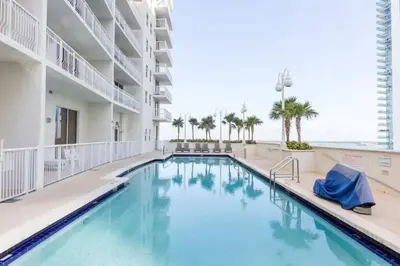 a swimming pool at a resort with the ocean in the background at Glam Studio: Sleeps 4 x Pool x Gym x Parking in Miami