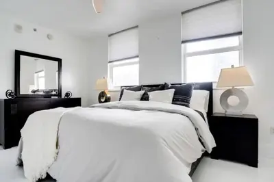 a white bedroom with a large bed and a mirror at Chic Penthouse: 3BR x Pool x Gym x 2 Parking Spots in Miami