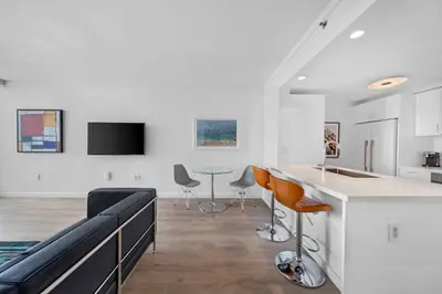 a kitchen and living room with a counter and chairs at 1-BD Condo in Coconut Grove - Water Views in Miami