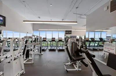 a gym with rows of treadmills and machines at 1-BD Condo in Coconut Grove - Water Views in Miami