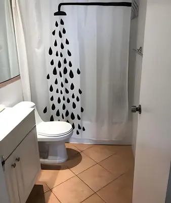 a bathroom with a toilet and a shower curtain at Pavilion - Best ocean sunrise-Miami Beach in Miami Beach