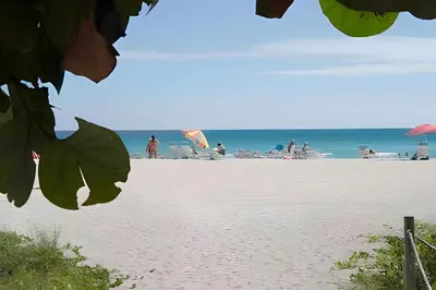 a beach with people on the sand and the ocean at Pavilion - Best ocean sunrise-Miami Beach in Miami Beach