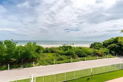 a road next to a beach with a white fence at Pavilion - Best ocean sunrise-Miami Beach in Miami Beach