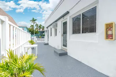 a walkway next to a white building with plants at 316 Seascape Unit 2 in Hollywood