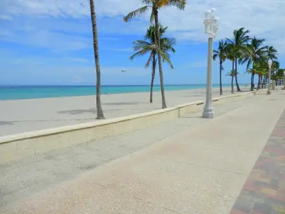 a sidewalk next to a beach with palm trees and a street light at 316 Seascape Unit 2 in Hollywood
