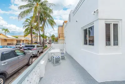 a car parked next to a white building with palm trees at 316 Footloose #3 in Hollywood