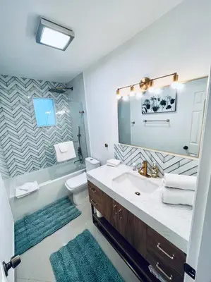 a bathroom with a sink and a toilet and a mirror at Designer Pool & Family Dream Home in Hollywood
