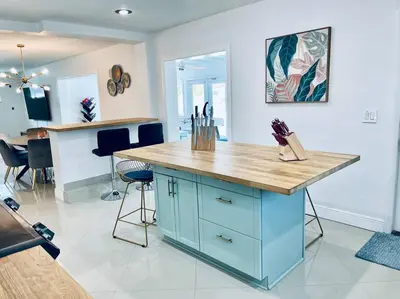 a kitchen with a blue island with a wooden counter top at Designer Pool & Family Dream Home in Hollywood