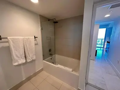 a bathroom with a tub and a shower with towels at 3Bed/2Bath Hallandale Beach in Hallandale Beach