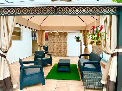 a patio with chairs and an umbrella and a table at SUPER CLOSE Beach, Airport, port, Downtown, Wynwood in Miami