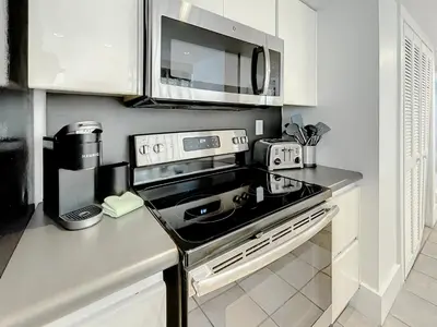 a kitchen with a stove and a microwave at CasaGrandeSouthBeach by AmericanVacationLiving 4RM in Miami Beach