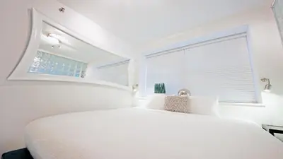 a white bedroom with a large white bed and a window at CasaGrandeSouthBeach by AmericanVacationLiving 4RM in Miami Beach
