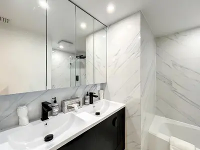 a white bathroom with a sink and a mirror at CasaGrandeSouthBeach by AmericanVacationLiving 4RM in Miami Beach