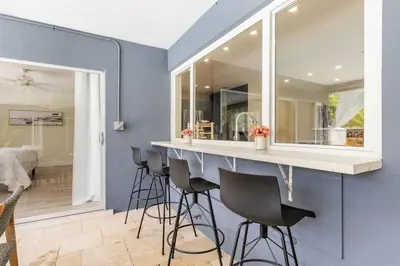 a bar with stools in a room with a blue wall at Spacious 4 Bedroom 3 Bathroom House with Heated Pool and Outdoor Shower close to FFL Airport and Cruise Port in Plantation