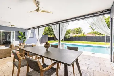 a dining room with a table and chairs and a pool at Spacious 4 Bedroom 3 Bathroom House with Heated Pool and Outdoor Shower close to FFL Airport and Cruise Port in Plantation
