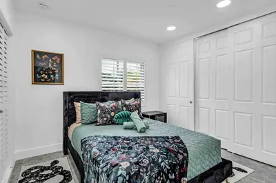 a bedroom with a bed with a green comforter at Miami Luxury Home! Next to Miami airport and beach in Miami