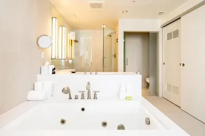 a white bathroom with a tub and a sink at High Floor Luxury 2BR 2BA, Sleeps 6, Resort Access - Horizon by HomeStakes Stays in Fort Lauderdale