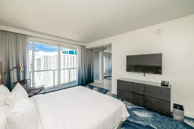 a hotel room with a large bed and a television at High Floor Luxury 2BR 2BA, Sleeps 6, Resort Access - Horizon by HomeStakes Stays in Fort Lauderdale
