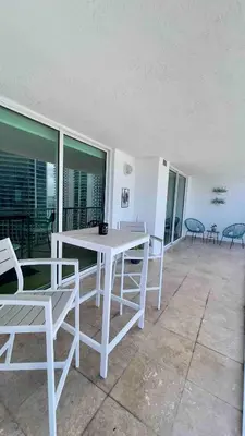 a white table and chairs on a balcony at Brickell Center w/City & Bay View + FREE Parking! in Miami