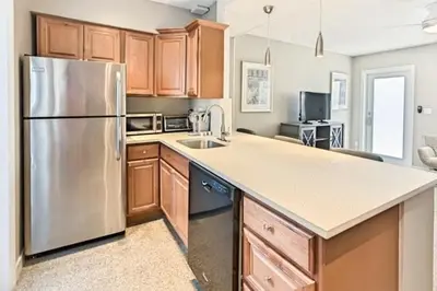 a kitchen with a stainless steel refrigerator and wooden cabinets at Wiltonplex B in Fort Lauderdale
