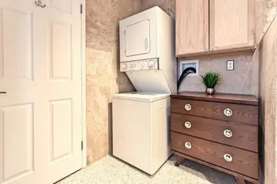 a kitchen with a refrigerator and a dresser with a laptop on it at Wiltonplex D in Fort Lauderdale