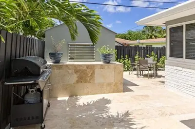 a backyard with a grill and a fence at Wiltonplex D in Fort Lauderdale