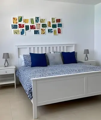 a bedroom with a white bed with blue pillows at Pavilion - Great ocean view -Miami Beach in Miami Beach
