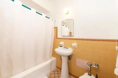 a bathroom with a white shower curtain and a sink at 6768 Collins Miami Stays in Miami Beach