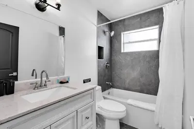 a white bathroom with a toilet and a sink at Modern Home 3 Bedrooms with Pool, 18 minutes to Ocean in Hollywood