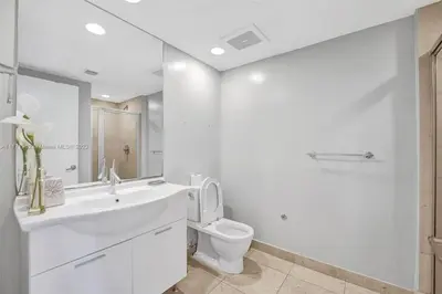 a white bathroom with a toilet and a sink at Waterfront Luxury Apartment 2 Bedrooms IconBrickell in Miami